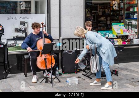 Cork, Irlande. 4 juin 2021. Le temps chaud et ensoleillé a fait sortir des foules de gens dans la ville de Cork aujourd'hui. Le week-end des fêtes du mois de juin devrait être très ensoleillé et très chaud. Harry Neal sur Cello et Karl Riedewald sur piano étaient des bus dans le centre-ville de Cork. Crédit : AG News/Alay Live News Banque D'Images