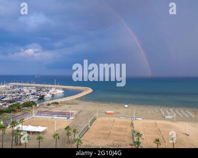 Vue aérienne sur le terrain de volley et la jetée avec yachts sur la mer Méditerranée près de la promenade des palmiers de Finikoudes dans la ville de Larnaca. Banque D'Images