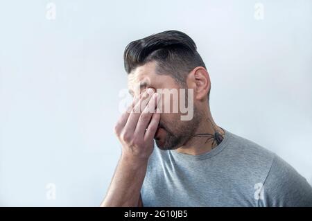 Portrait d'un jeune homme souffrant de maux de tête graves, de stress, de tension et de migraine. Contrarié malheureux et stressé jeune homme. Banque D'Images