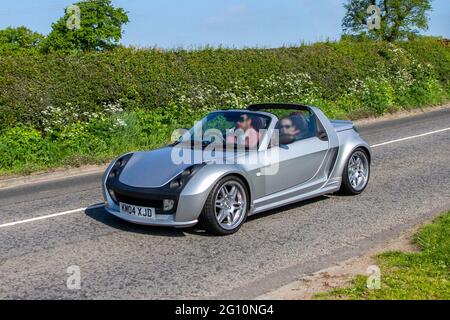 2004 argent Smart Roadster Brabus Auto à toit ouvert, essence 698cc ; circulation automobile, véhicules en mouvement, voitures, conduite de véhicules sur les routes britanniques, moteurs, automobile, réseau routier, Banque D'Images