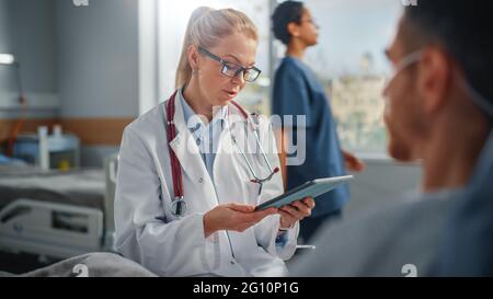 Service hospitalier : repos au lit un homme caucasien écoute une femme expérimentée médecin expliquant les résultats des tests, donne des conseils, utilisé Tablet PC Banque D'Images