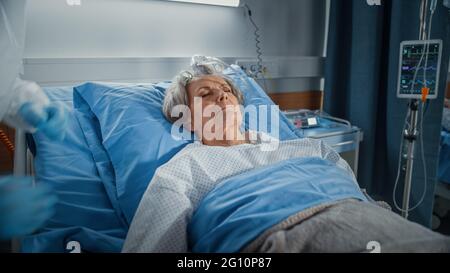 Hôpital: Portrait d'une belle femme âgée dormant au lit, se rétablissant complètement après la maladie et la chirurgie réussie. Femme sénior rêvant de Banque D'Images