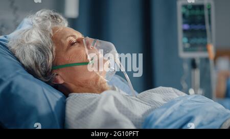 Hôpital: Portrait d'une belle femme âgée portant un masque d'oxygène dormant au lit, se rétablissant complètement après la maladie et la chirurgie réussie. Senior Banque D'Images