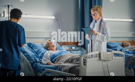 Service hospitalier : infirmière en chef féminine et médecin professionnel effectuant des tours de contrôle sur le sommeil de la femme âgée patient reposant dans le lit. Ils parlent, vérifier Banque D'Images