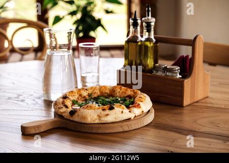 Pizza et eau dans une verseuse en verre sur une table en bois de style vintage. Restaurant italien de fond pour votre conception. Concept de style de vie du restaurant. Conce alimentaire Banque D'Images