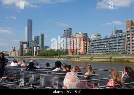 Tamise, Londres, 2021. Touristes appréciant une croisière sur la Tamise avec Canary Wharf en arrière-plan lors d'une magnifique journée d'été Banque D'Images