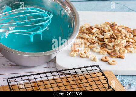 crème glacée bleue fouettée dans un bol en métal sur une table avec des biscuits fraîchement cuits et une planche de séchage en métal Banque D'Images