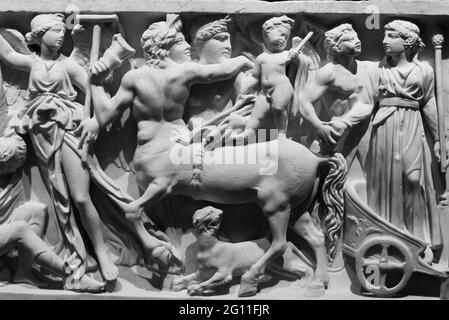 Photo en noir et blanc de sculptures romaines anciennes représentant une scène de bataille mythologique gravée sur un mur de marbre Banque D'Images