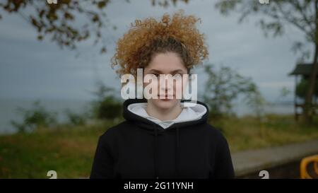 Portrait d'une belle jeune femme aux cheveux bouclés vêtus de sport. Banque D'Images