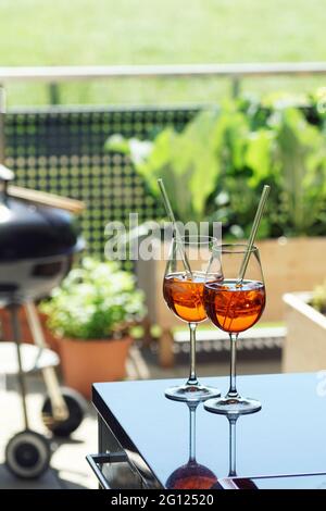 deux boissons estivales (venetian spritz, aperol) sur une table sur un jardin avec balcon Banque D'Images