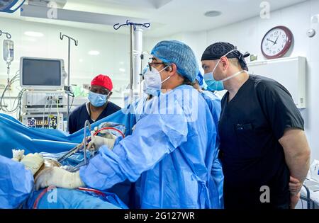 Médecin et assistance équipe médicale effectuant la chirurgie sur un patient avec foyer et moment stressant dans la salle d'opération dans l'hôpital ou la clinique de santé conc Banque D'Images