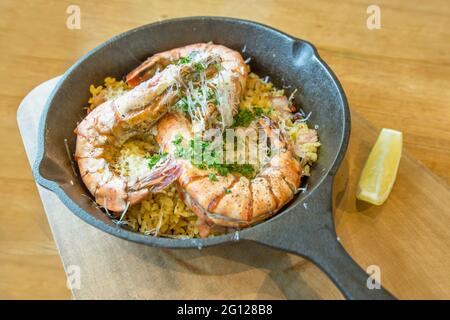 Crevettes de rivière cuites au four avec riz frit et fromage sur fond de bois. Banque D'Images