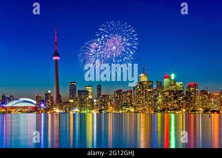 Vue sur les gratte-ciel de Toronto avec la Tour CN et le Centre Rogers à l'heure de la tombée de la nuit, superbes couleurs lumineuses reflétées sur l'eau du lac Banque D'Images