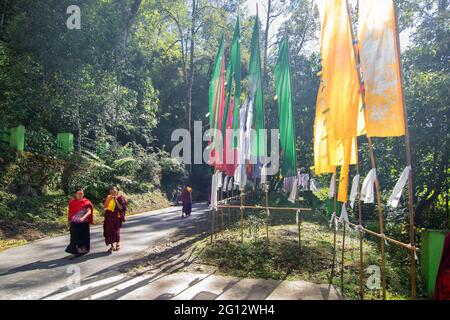 SAMDRUPTSE, SIKKIM, INDE - OCTOBRE 20th 2016 : Monks marchant sur la route de la statue de Samdruptse, drapeaux de prière agitant sur le côté de la route . Samdruptse. Banque D'Images