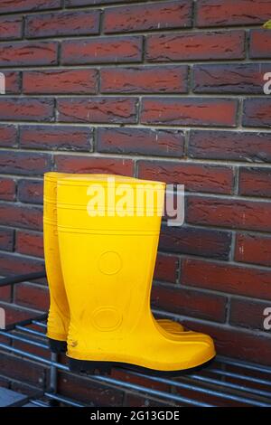 bottes en caoutchouc jaune près de l'entrée de la maison Banque D'Images