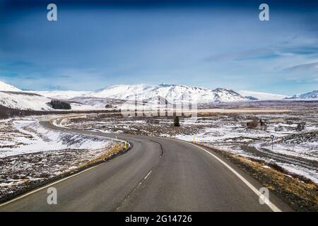 Voyage en Islande, l'autoroute le long des montagnes couvertes de neige, paysage islandais incroyable, vue pittoresque en hiver, la nuit passe à un soleil Banque D'Images