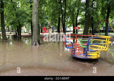 Terrain de jeu coloré dans le parc après une forte pluie. L'aire de jeux est inondée d'eau. Banque D'Images
