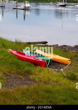 trio de kayaks colorés reposant sur les berges herbeuses Banque D'Images