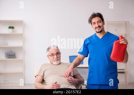 Vieux patient virant jeune homme médecin gastro-entérologue Banque D'Images