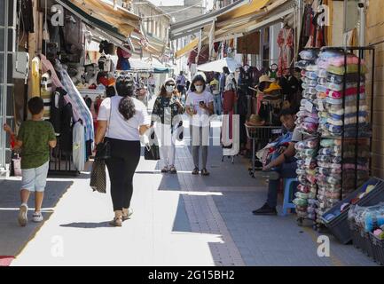 Nicosie, secteur chypriote turc de la capitale divisée. 4 juin 2021. Les personnes portant un masque facial font du shopping dans la partie nord de la vieille ville de Nicosie, qui fait partie du secteur chypriote turc de la capitale divisée, Chypre, le 4 juin 2021. Chypre a rouvert vendredi les neuf points de passage de la zone tampon qui divise l'île, qui avait été complètement fermée depuis décembre 2020 en tant que mesure contre la dispersion de la COVID-19. Les personnes doivent présenter un test d'antigène négatif de 7 jours ou un test PCR et une carte d'identité. Credit: George Christophorou/Xinhua/Alay Live News Banque D'Images