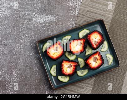 Hareng en fourrure - une salade russe traditionnelle de hareng et de légumes sur une assiette rectangulaire sur fond sombre. Vue de dessus, plan d'appartement Banque D'Images