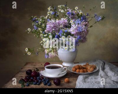 Encore la vie avec beau bouquet de fleurs sur une table de thé Banque D'Images