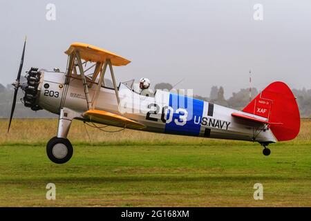 Un avion biplan modèle 75 de Boeing Searman des années 1930 aux couleurs de la marine américaine vient pour un atterrissage Banque D'Images