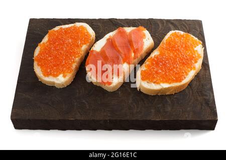 Sandwichs ouverts avec œufs de saumon et filet sur panneau de bois Banque D'Images