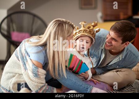 Les jeunes parents aiment jouer avec leur petite fille dans une atmosphère gaie à la maison. Famille, ensemble, amour, maison Banque D'Images