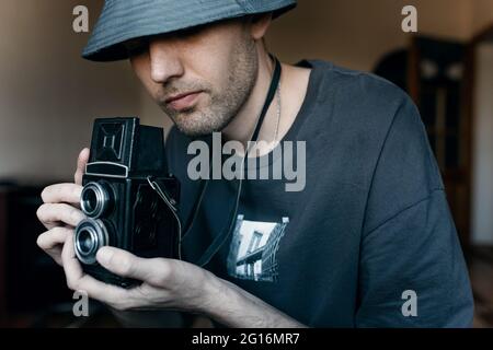 Guy avec appareil photo rétro à la main prend des photos Banque D'Images