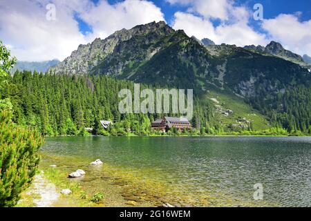 Le beau lac de Popradske pleso, entouré par les montagnes de Tatra, et un hôtel de montagne. Slovaquie. Image prise sur le terrain public. Banque D'Images