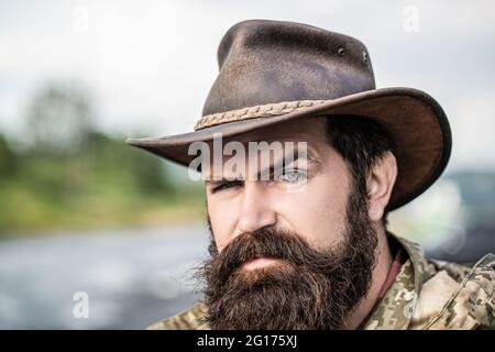 Cowboys en chapeau. Jolie macho barbu. Cow-boys non rasés. Cow-boy américain. Chapeau de cowboy en cuir. Portrait d'un jeune homme portant un chapeau de cow-boy Banque D'Images