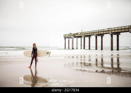 Surfeur debout sur la plage à Saint Augustine, Floride, USA, 2015 Banque D'Images