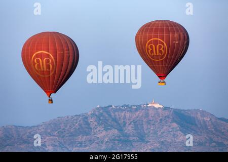 Vue aérienne tôt le matin de deux ballons à air chaud qui flottent au-dessus des temples de la zone archéologique de Bagan, Myanmar (Birmanie). Banque D'Images