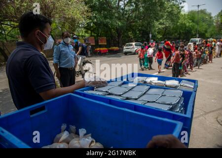 New Delhi, Inde. 05e juin 2021. Les enfants indiens attendent dans une file d'attente pour de la nourriture.les paquets de nourriture sont distribués aux pauvres et aux mendiants par l'organisation religieuse arsha Dharma Parishad du Temple Uttara Guruvayoorappan à New Delhi; ils servent 850 paquets de nourriture chaque jour. Crédit : SOPA Images Limited/Alamy Live News Banque D'Images