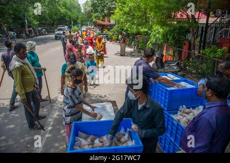 New Delhi, Inde. 05e juin 2021. La femme indienne reçoit des paquets de nourriture.les paquets de nourriture sont distribués aux pauvres et les mendiants par l'organisation religieuse arsha Dharma Parishad du temple d'Uttara Guruvayoorappan à New Delhi; ils servent 850 paquets de nourriture chaque jour. Crédit : SOPA Images Limited/Alamy Live News Banque D'Images