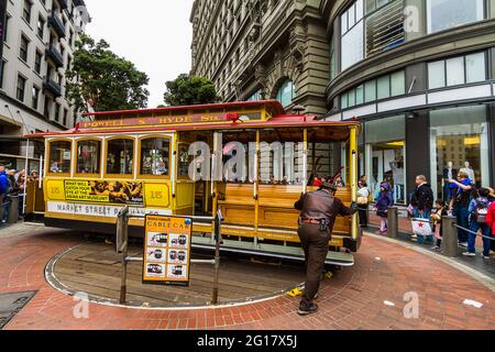 Un téléphérique sur la plaque tournante et les touristes attendant une promenade à San Francisco Banque D'Images