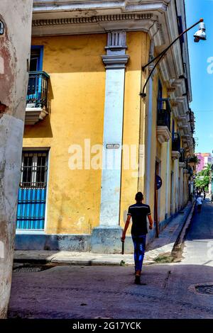 Homme marchant au coin des rues Habana et Aguiar dans la vieille Havane, Cuba Banque D'Images