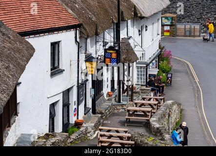 Un pub dans le village de Lynmouth, Devon, Angleterre, Royaume-Uni avec des visiteurs appréciant la journée Banque D'Images