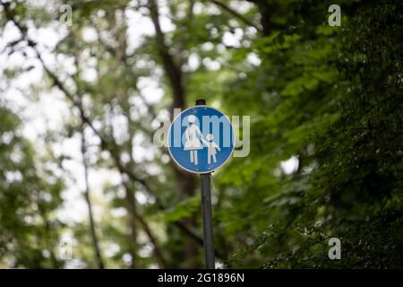 signe de chemin piéton bleu entre les arbres et les buissons Banque D'Images