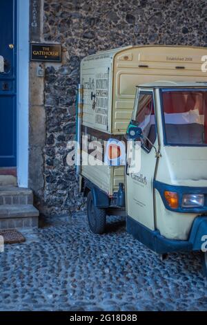 Une camionnette mobile garée sur les pierres de galets devant un ancien mur de pierre dans la ville de Norwich dans Norfolk Banque D'Images
