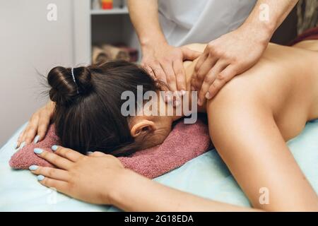 Un homme est un chiropraticien faisant un massage à une femme dans le cou et des muscles trapèzius dans son bureau. Banque D'Images