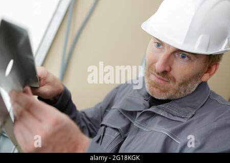 homme constructeur dans le casque inspectant le casque Banque D'Images