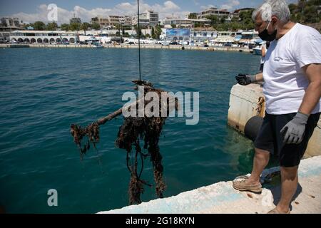 Rafina, Grèce. 5 juin 2021. Un volontaire aide à récupérer une pile de déchets au port de Rafina, à environ 30 km à l'est d'Athènes, Grèce, le 5 juin 2021. La Grèce met en avant la pollution par les plastiques marins, qui marque la Journée mondiale de l'environnement, qui tombe le 5 juin, et la Journée mondiale des océans le 8 juin, avec le lancement par le ministère de la navigation d'un projet de nettoyage de huit ports grecs. Credit: Lefteris Partsalis/Xinhua/Alamy Live News Banque D'Images