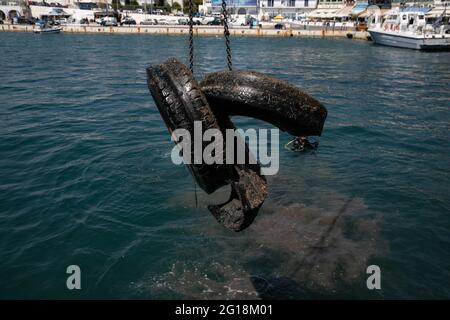 Rafina, Grèce. 5 juin 2021. Des pneus en caoutchouc sont tirés au port de Rafina, à environ 30 km à l'est d'Athènes, en Grèce, le 5 juin 2021. La Grèce met en avant la pollution par les plastiques marins, qui marque la Journée mondiale de l'environnement, qui tombe le 5 juin, et la Journée mondiale des océans le 8 juin, avec le lancement par le ministère de la navigation d'un projet de nettoyage de huit ports grecs. Credit: Lefteris Partsalis/Xinhua/Alamy Live News Banque D'Images