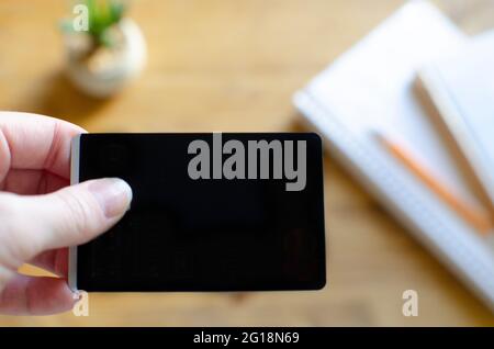 Main avec une carte de crédit vierge noire sur le travail à partir du bureau à la maison Banque D'Images