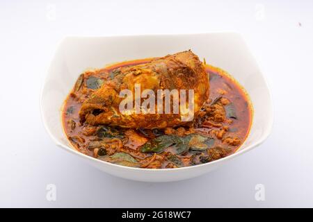 Curry à la tête de poisson, curry à la tête de poisson Rohu dans le style sud indien, disposé dans un bol en céramique blanc, isolé sur fond blanc. Banque D'Images