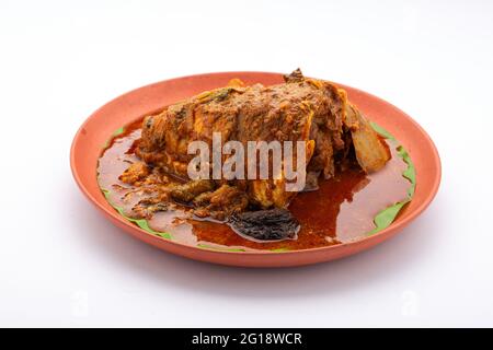 Curry de tête de poisson, curry de tête de poisson de Rohu dans le style sud indien arrangé dans une faïence isolée sur fond blanc. Banque D'Images