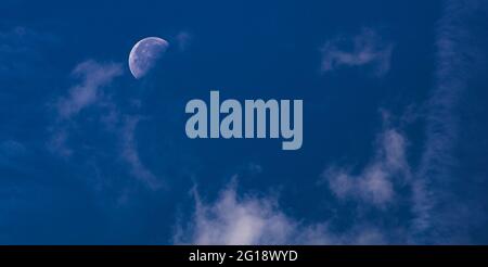 Pleine lune sur une nuit claire comme un motif de carte postale panoramique. Ciel clair avec la lune en arrière-plan. Ciel bleu clair avec bande lumineuse de nuages. Banque D'Images