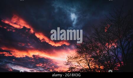 Ciel panoramique spectaculaire et nuageux aux couleurs éclatantes dans une ambiance de vie pleine d'espoir. Aube au printemps avec des nuages spectaculaires. Banque D'Images